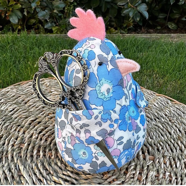 Hand made blue floral Liberty Fabric chicken pincushion holding sewing scissors