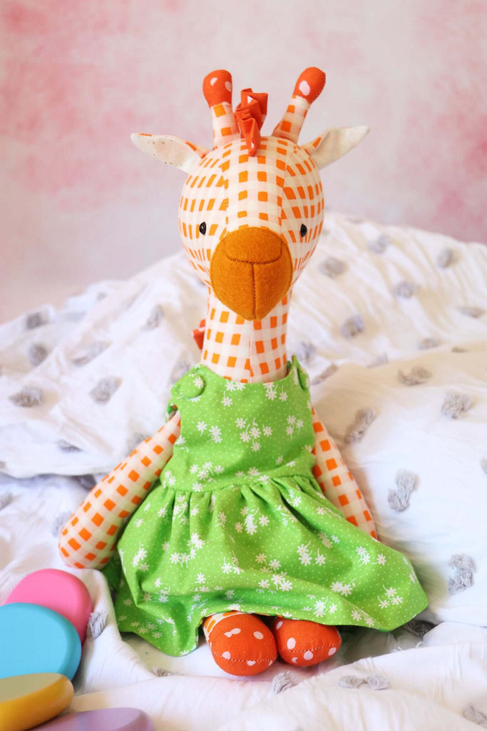 Orange gingham giraffe soft toy in a green floral dress made from RicRac sewing pattern.