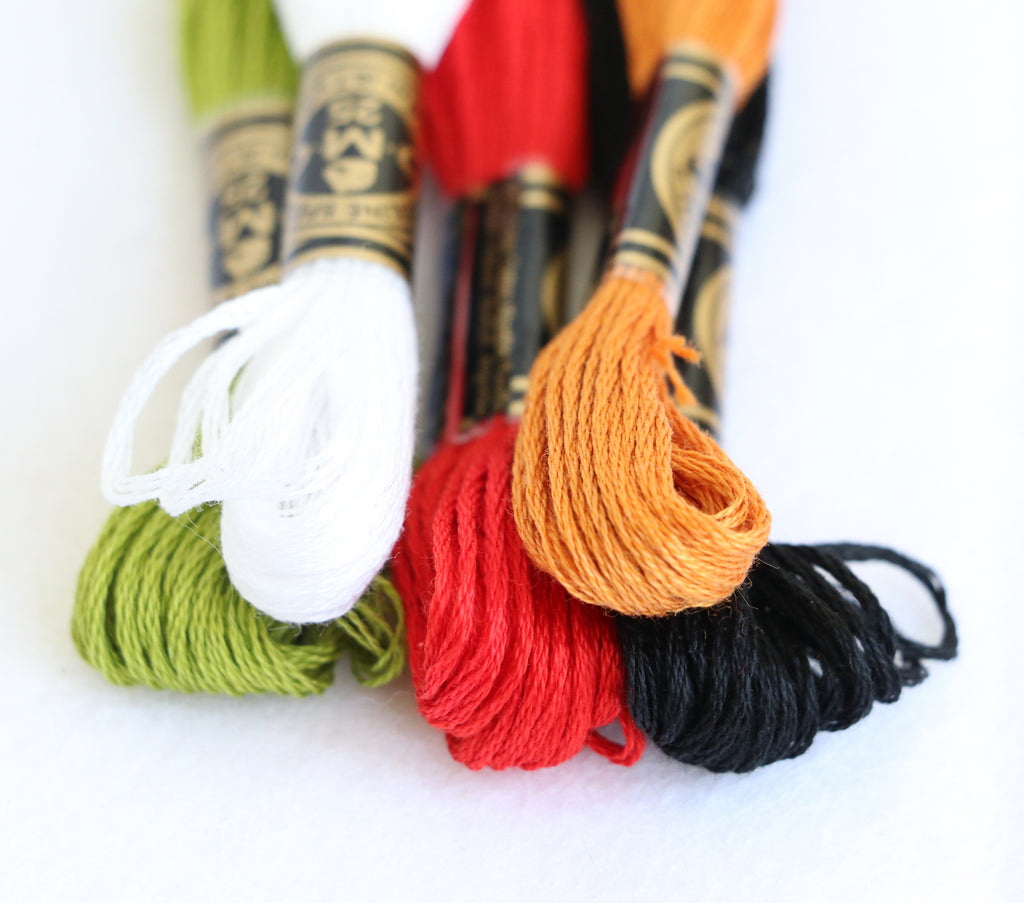 Daryl & Russ sewing kit colored embroidery threads in green, white, red, orange, and black for crafting.