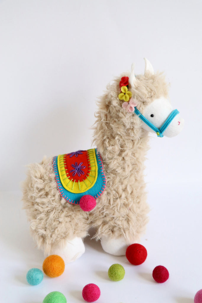 Curly plush llama soft toy with colorful felt flower garland necklace, made using a DIY sewing pattern from RicRac.